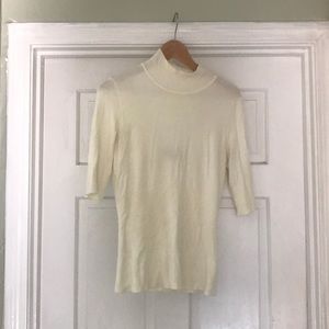 Lightweight sweater in cream. Open back.